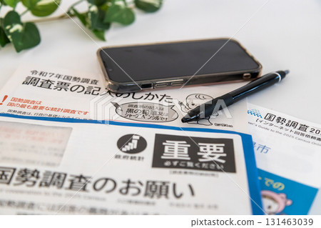 人口普查庫存照片:人口普查通知、智慧型手機和書寫工具 人口普查庫存照片:人口普查通知、智慧型手機和書寫工具 131463039