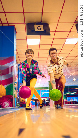 Man and woman in retro outfits bowling together with bright colorful balls 131463259