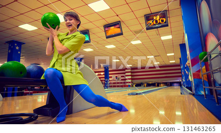 Joyful woman holding green bowling ball with excitement Joyful woman holding green bowling ball with excitement 131463265