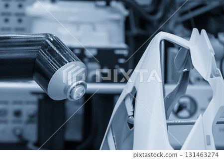 Close up scene the automatic painting robot working with automotive parts in the light blue scene. Close up scene the automatic painting robot working with automotive parts in the light blue scene. 131463274