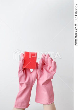 Hand in pink rubber glove holding a sponge for cleaning. Household cleaning and hygiene concept 131463357