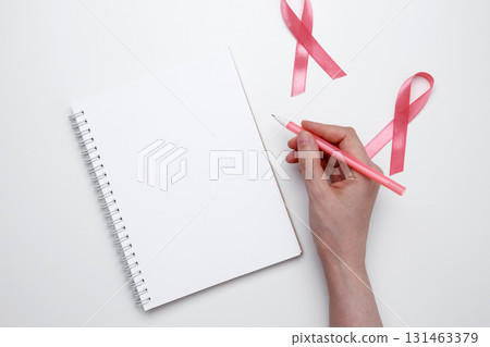 Woman scheduling preventive checkup with visible pink ribbon symbolizing breast cancer awareness Woman scheduling preventive checkup with visible pink ribbon symbolizing breast cancer awareness 131463379