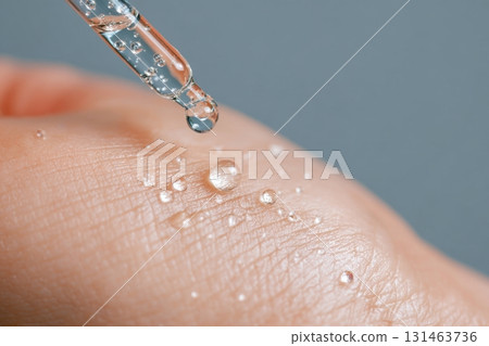 Transparent serum drops on smooth skin with macro detail 131463736