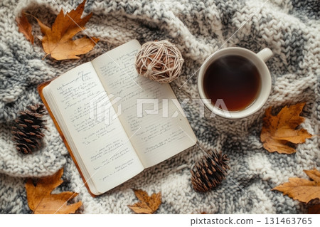 Flat lay showing autumn equinox rituals with journal dried leaves and cup of tea in natural textures setting 131463765