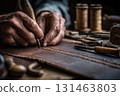 Craftsman stitching leather by hand close-up 131463803