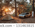 Electric car charging near tent under pine trees, eco-travel 131463815