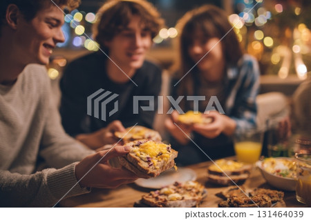 Young people enjoying savory comfort snacks cozy home relaxed atmosphere 131464039