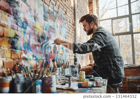 Artist painting mural on brick wall in converted warehouse showing urban art and creative process 131464332