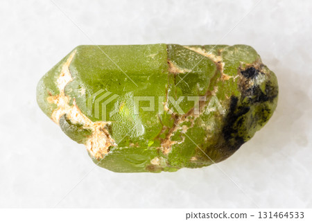 sample of rough peridod crystal on white marble 131464533