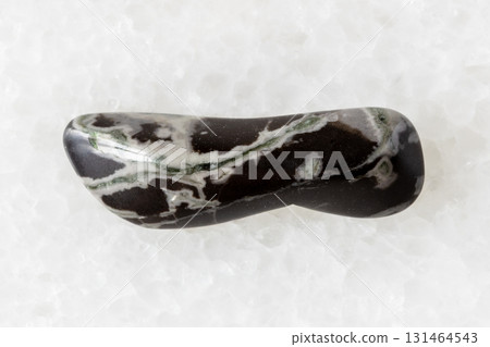 sample of tumbled hornfels mineral on white marble 131464543