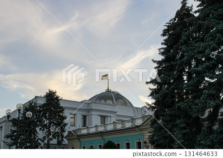 Ukrainian flag flies proudly atop the dome of a majestic government parliament building, symbolizing national sovereignty and political power in Kyiv, Ukraine Ukrainian flag flies proudly atop the dome of a majestic government parliament building, symbolizing national sovereignty and political power in Kyiv, Ukraine 131464633