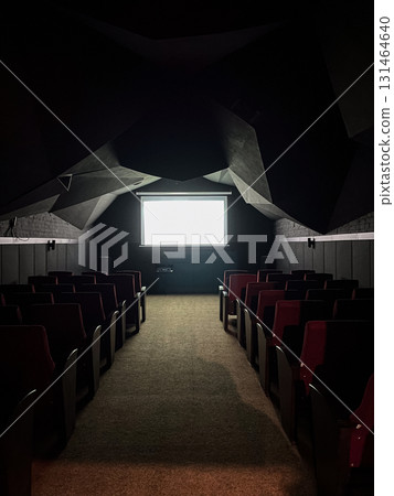 Dark, empty cinema room with a luminous blank projector screen and red seats, evoking anticipation for immersive entertainment or corporate presentation 131464640
