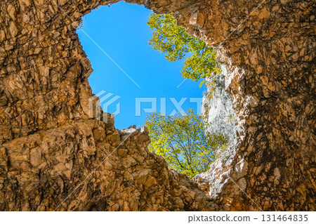 Hole in rock formation showing sky, suitable for autumn backgrounds, textures, and landscape projects 131464835