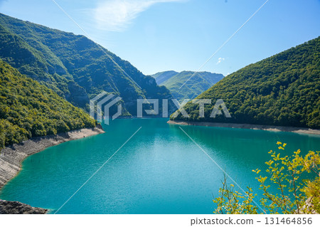 Scenic view of Piva Lake surrounded by forest covered mountains in Montenegro, natural landscape with clear blue water 131464856