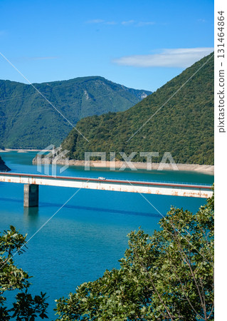 Scenic side view of a bridge crossing Piva Lake in Montenegro, surrounded by high mountains and natural landscape Scenic side view of a bridge crossing Piva Lake in Montenegro, surrounded by high mountains and natural landscape 131464864