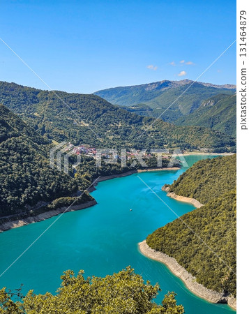 Panoramic view of Piva Lake surrounded by forested mountains in Montenegro, highlighting rugged natural landscape, ideal for travel, adventure, and outdoor projects Panoramic view of Piva Lake surrounded by forested mountains in Montenegro, highlighting rugged natural landscape, ideal for travel, adventure, and outdoor projects 131464879