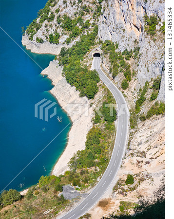 Scenic view of a road running along a cliff beside Piva Lake in Montenegro, surrounded by mountains and natural landscape, ideal for travel, adventure, and nature projects Scenic view of a road running along a cliff beside Piva Lake in Montenegro, surrounded by mountains and natural landscape, ideal for travel, adventure, and nature projects 131465334