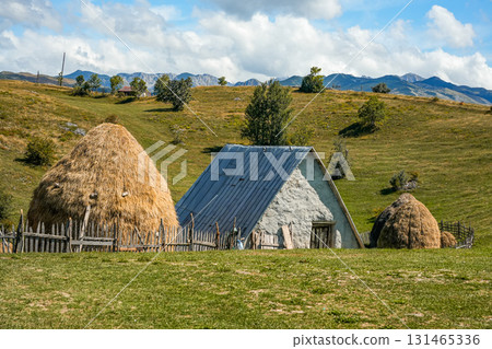 Scenic view of traditional mountain farms with clay houses, haystacks, and surrounding hills, showcasing rustic rural life and natural landscape, ideal for travel, lifestyle, and cultural projects Scenic view of traditional mountain farms with clay houses, haystacks, and surrounding hills, showcasing rustic rural life and natural landscape, ideal for travel, lifestyle, and cultural projects 131465336