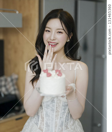 Woman is holding a cake with a heart on it 131465360