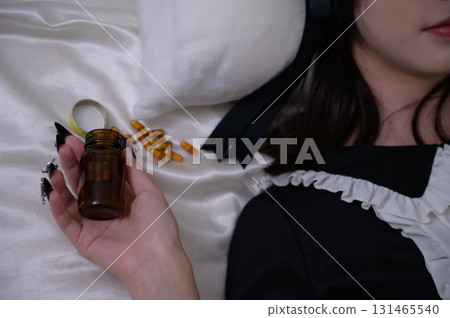 一名地雷女孩躺在床上，拿著藥 131465540