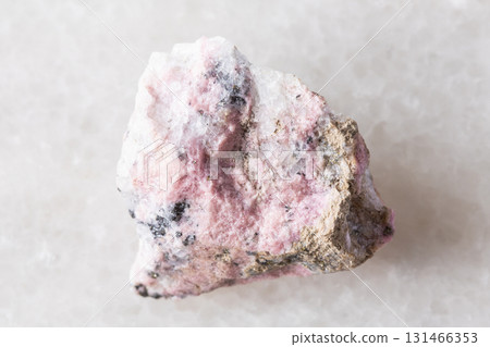 sample of raw pyroxmangite mineral on white marble 131466353