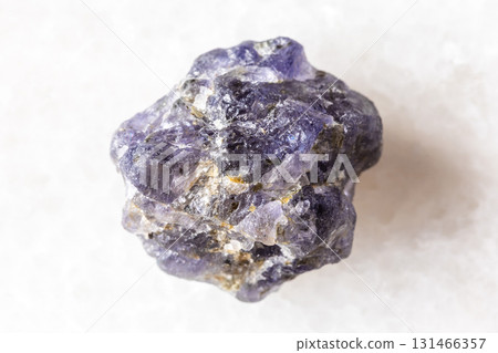 sample of rough iolite mineral on white marble 131466357