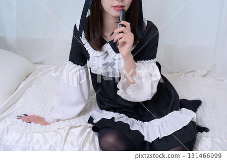 A landmine girl smoking an e-cigarette in bed 131466999