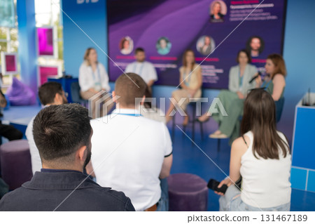 Panel discussion at a modern conference with speakers and audience in blue venue Panel discussion at a modern conference with speakers and audience in blue venue 131467189