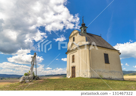 Chapel on a travertine hill of The Siva Brada in Spis region in Slovakia, Europe. Picturesque countryside view featuring a charming old chapel on a hill with a cross statue against a partly cloudy sky 131467322