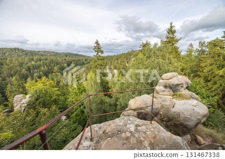 Landscape of Adrspach-Teplice Rocks area, in Hradec Kralove Region in the Czech Republic, Europe. Overlook point with railings and a forest view with a cloudy sky backdrop. Forest, Trees and sky. Landscape of Adrspach-Teplice Rocks area, in Hradec Kralove Region in the Czech Republic, Europe. Overlook point with railings and a forest view with a cloudy sky backdrop. Forest, Trees and sky. 131467338