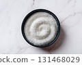Monosodium glutamate in a dark blue bowl over marble kitchen counter. 131468029