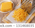 Whole and shredded cheddar cheese close-up. 131468035