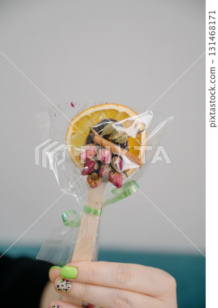 Wooden stick with dried fruit, spices, and flowers. 131468171