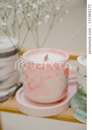 Close-up of a handmade candle in a pink marble candlestick Close-up of a handmade candle in a pink marble candlestick 131468172