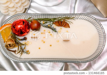 Handmade boat-shaped candle with wooden wicks and Christmas decorations Handmade boat-shaped candle with wooden wicks and Christmas decorations 131468185