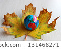 The onset of calendar autumn on the European continent, visible on a globe lying on a fallen autumn leaf 131468271
