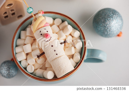 Marshmallow Snowman in Mug with Christmas Ornaments and Lights 131468336