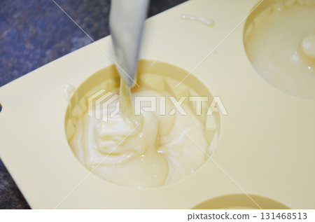 pouring liquid muffin batter into silicone baking mold pouring liquid muffin batter into silicone baking mold 131468513