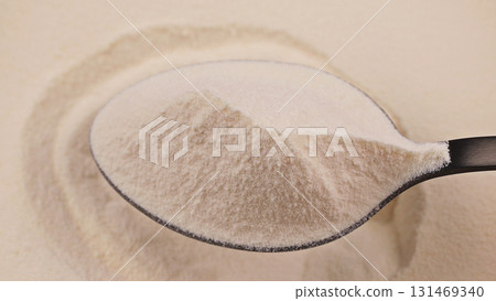 Close-up of a spoon filled with fine collagen powder on a smooth background. Dietary supplement, collagen, protein or food additive concept for health, wellness and nutrition supplement industries 131469340
