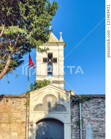 Historic bell tower and stone wall under a bright blue sky Historic bell tower and stone wall under a bright blue sky 131469431