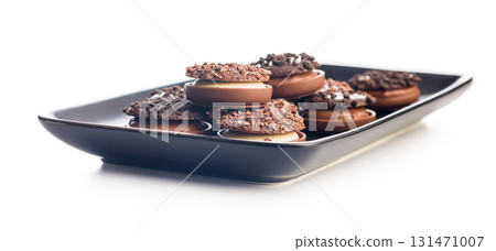 Sweet chocolate pralines. Chocolate candies on plate isolated on white background. 131471007