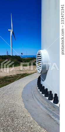 Industrial bolts on the base of a wind turbine with blades in the background. Concept of renewable energy, sustainable development, and eco-friendly technologies. 131471341