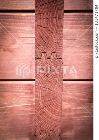 Close-Up of Interlocking Wooden Corner Joint with Natural Grain and Cracks in Sunlight 131471784