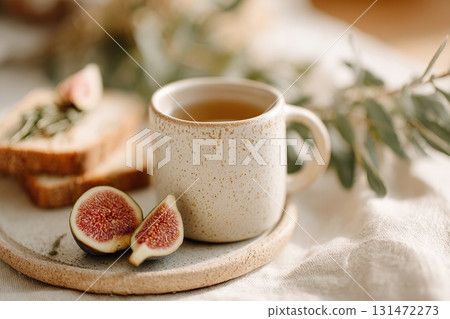 Breakfast featuring sourdough toast and fresh figs on a rustic table with tea 131472273