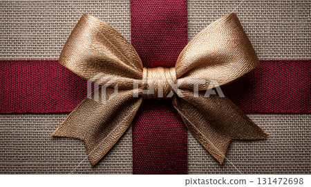 Bordeaux and gold satin ribbon on a gray textured background 131472698