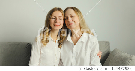 Family portrait, happy two women, smiling mature mother and adult daughter together hugging at home 131472922