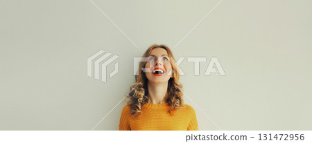 Happy surprised young woman laughing looking up, blank copy space background Happy surprised young woman laughing looking up, blank copy space background 131472956