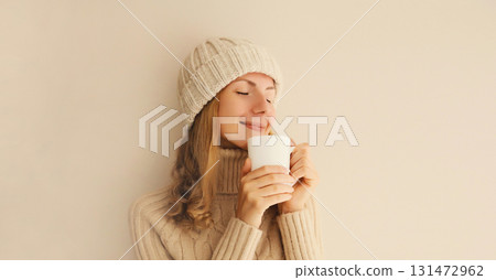 Winter portrait of happy satisfied young woman enjoying cup of hot tasty coffee drink in the morning 131472962