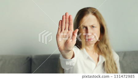 Woman shows stop, no or protest sign with palm of hand, refusal gesture, domestic violence Woman shows stop, no or protest sign with palm of hand, refusal gesture, domestic violence 131472985