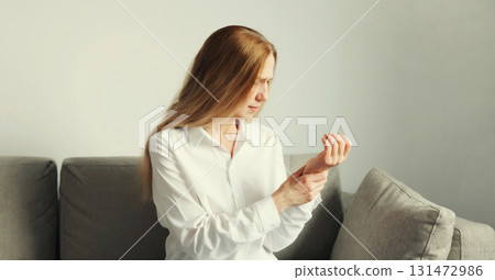 Unhealthy young woman suffers from wrist pain, tunnel syndrome, unwell girl touching her hand Unhealthy young woman suffers from wrist pain, tunnel syndrome, unwell girl touching her hand 131472986